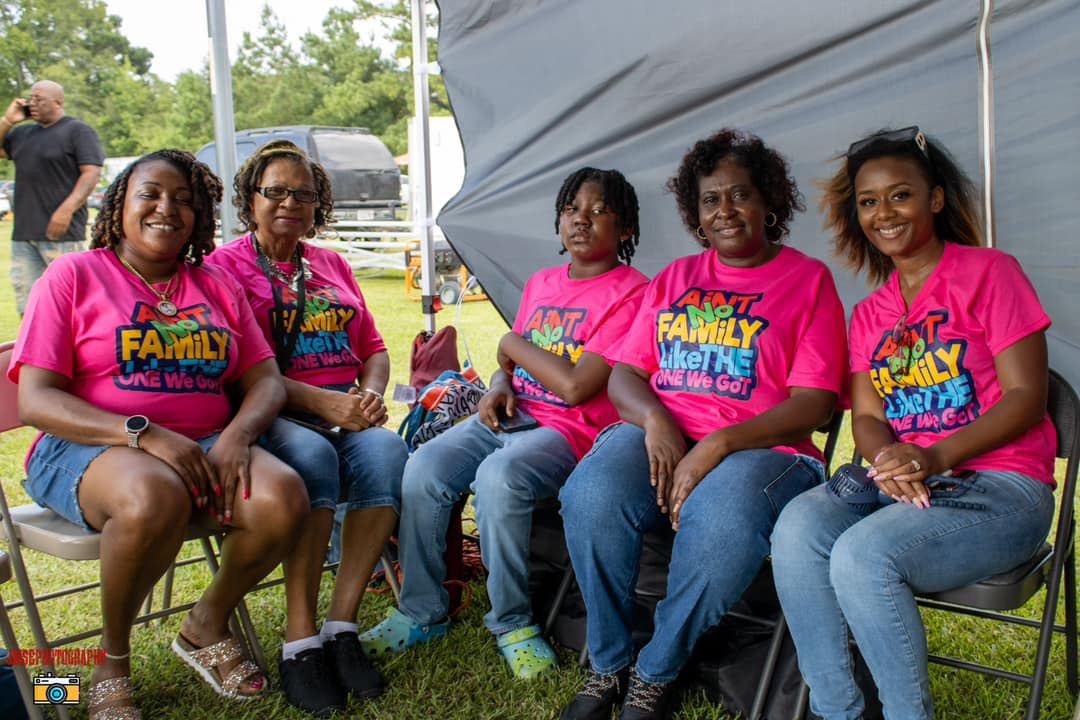Family members seated together in matching pink Ain't No Family shirts