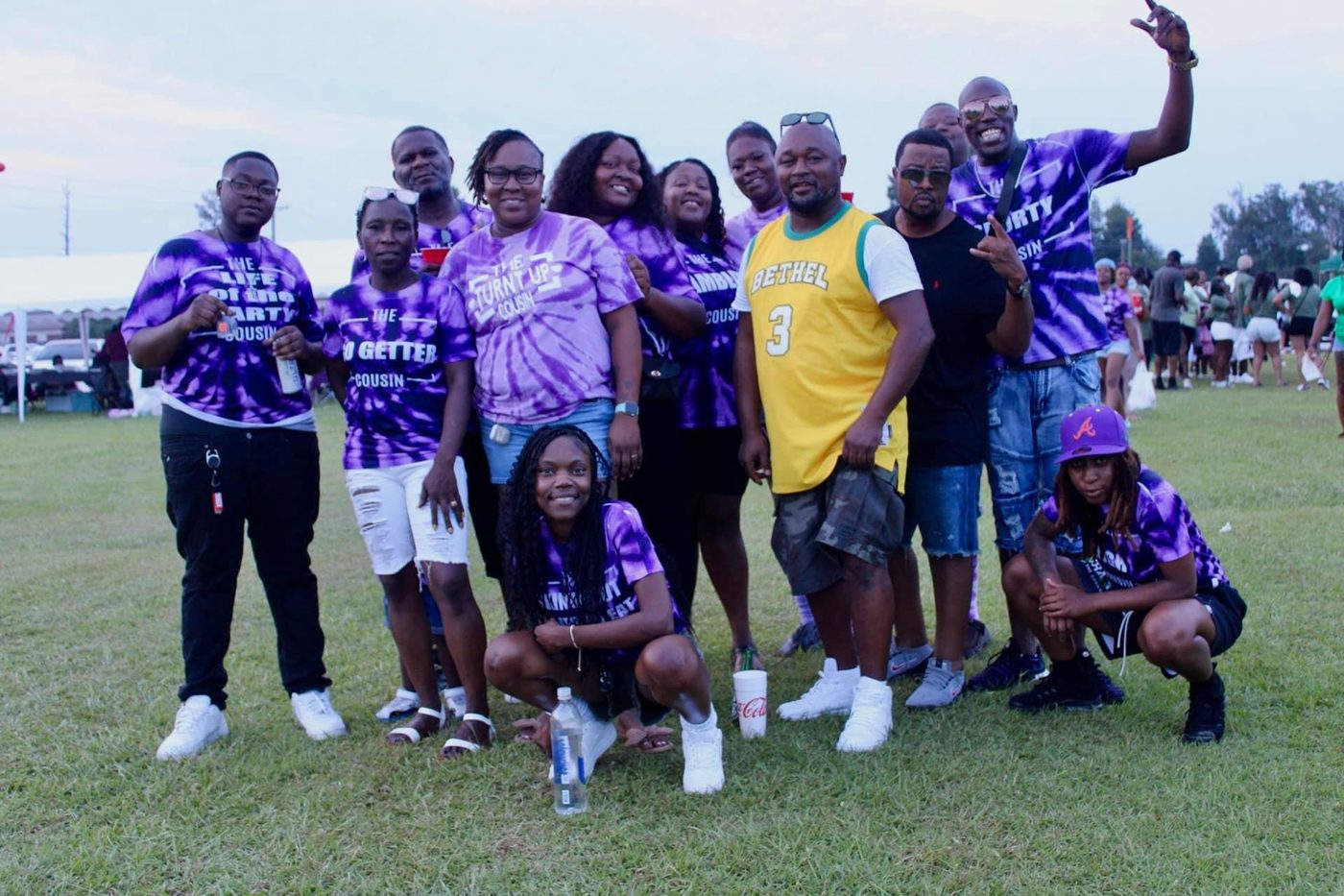 Family in purple tie-dye cousin shirts posing together at Cousins Day