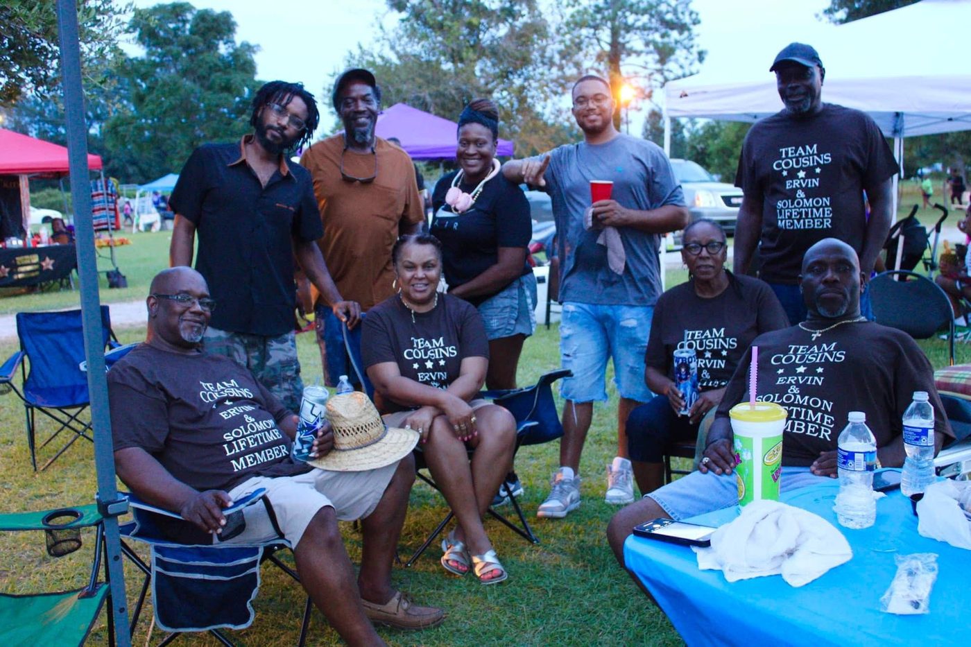 The Ervin and Solomon family relaxing under their tent in matching Team Cousins shirts